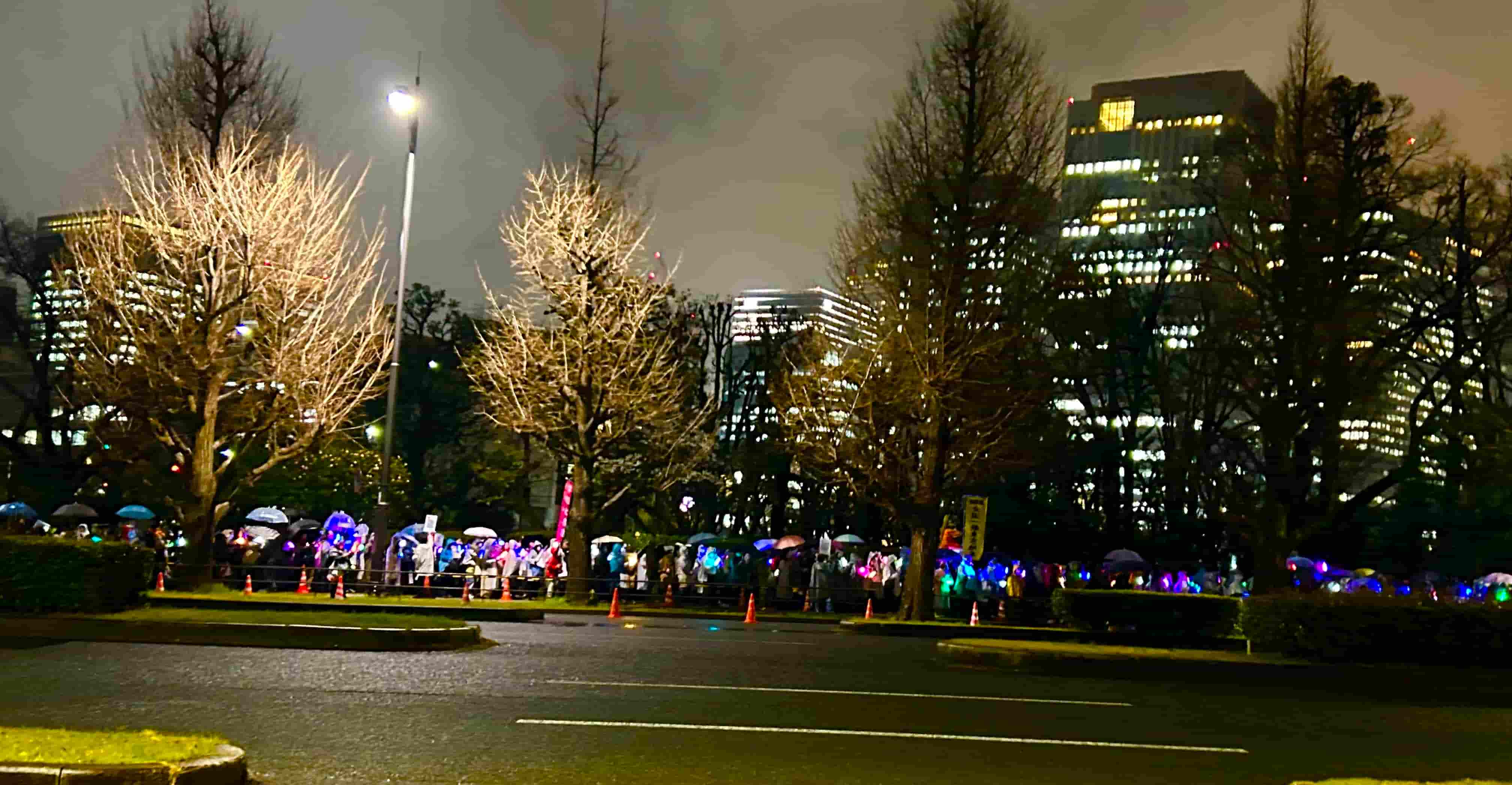 国会前で傘とライトを掲げる人々のデモ風景
